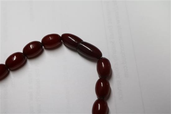 A single strand graduated simulated cherry amber oval bead necklace, gross weight 68 grams, 70cm.